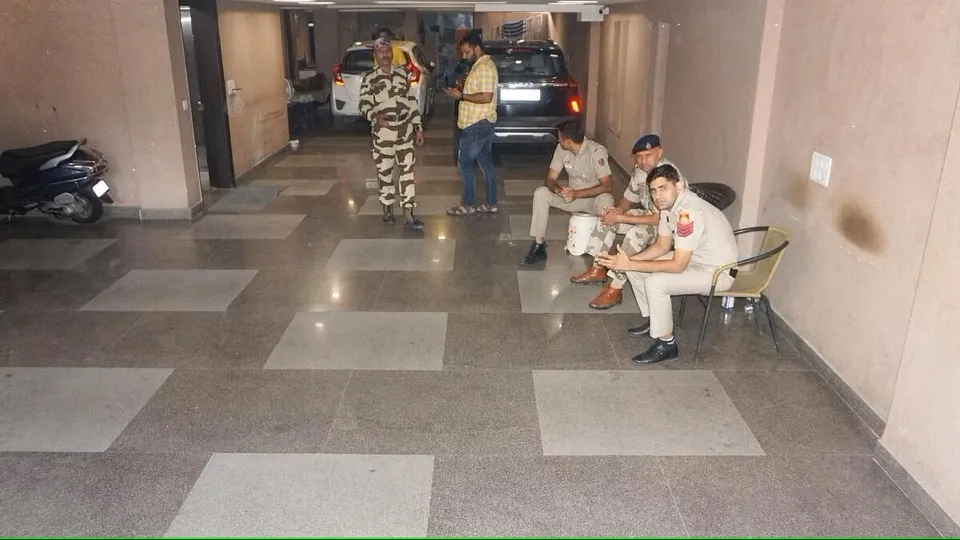 Security personnel guard during raids by Delhi Police's Special Cell on the premises of NewsClick at Saket, in New Delhi