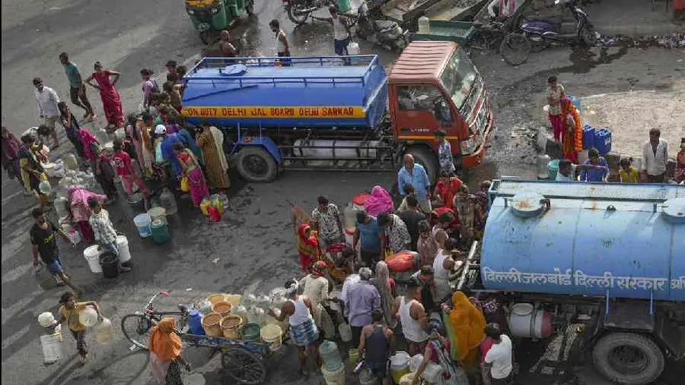 People collect drinking water from a tanker of Delhi Jal Board on a hot summer day as water crisis continues, at a slum in Geeta Colony area, in East Delhi