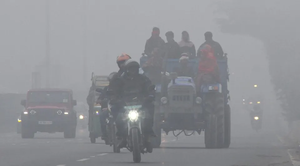 Tractor and bike on the road in a foggy morning