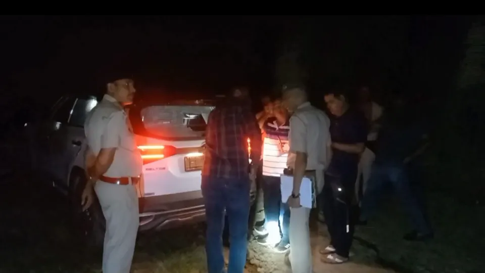 Police personnel gather near a damaged vehicle after a shootout in which three members of Himanshu Bhau gang