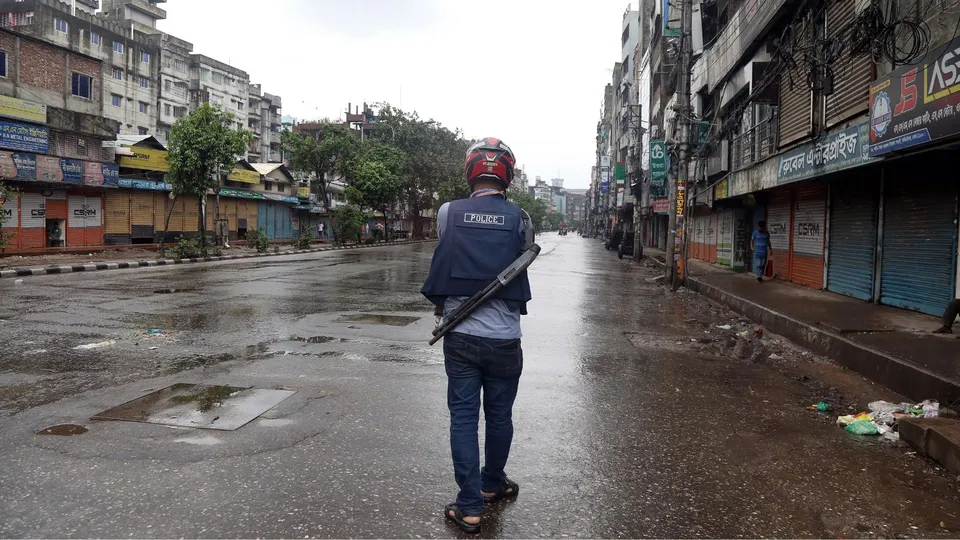 A Bangladeshi police officer patrols on the street after the government imposed a new curfew, in Dhaka, Bangladesh, 05 August 2024.