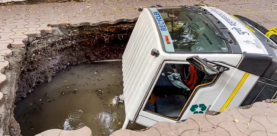 Pune Municipal Corporation (PMC) vehicle gets stuck after falling into a caved in portion of a road, in Pune, Maharashtra, Friday, Sept. 20, 2024.