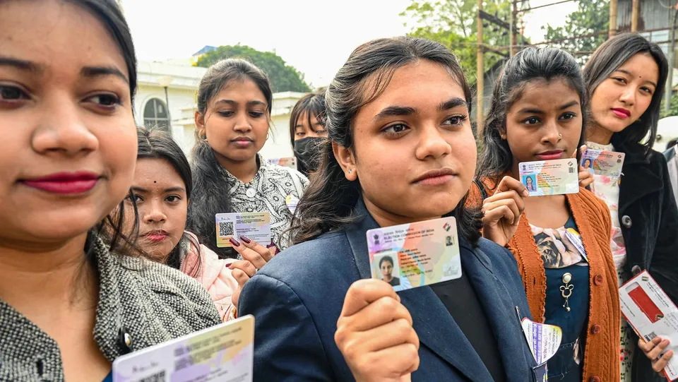 Young voters show their Electors Photo Identity Cards (EPIC), on National Voters' Day, in Agartala