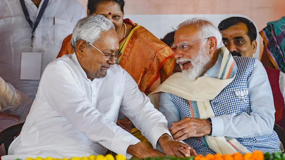 Bihar chief minister Nitish Kumar sharing a ligher moment with Prime Minister Narendra Modi which was termed as touching feet