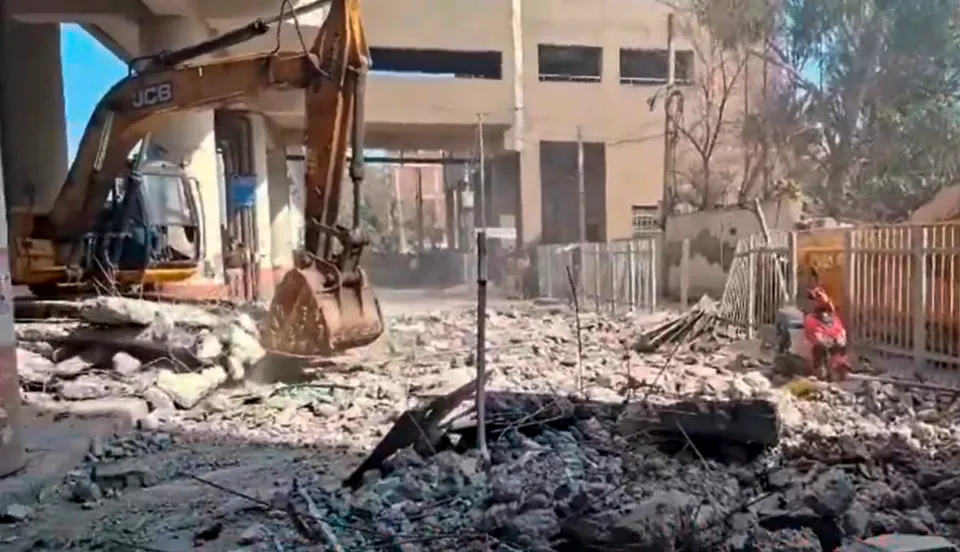 An earthmover removes debris after the collapse of a portion of Gokalpuri Metro Station, in New Delhi