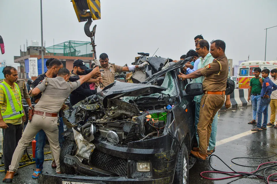 olice personnel and others near the wreckage of a car after a head-on collision with a bus on Ghaziabad-Meerut Expressway, in Ghaziabad