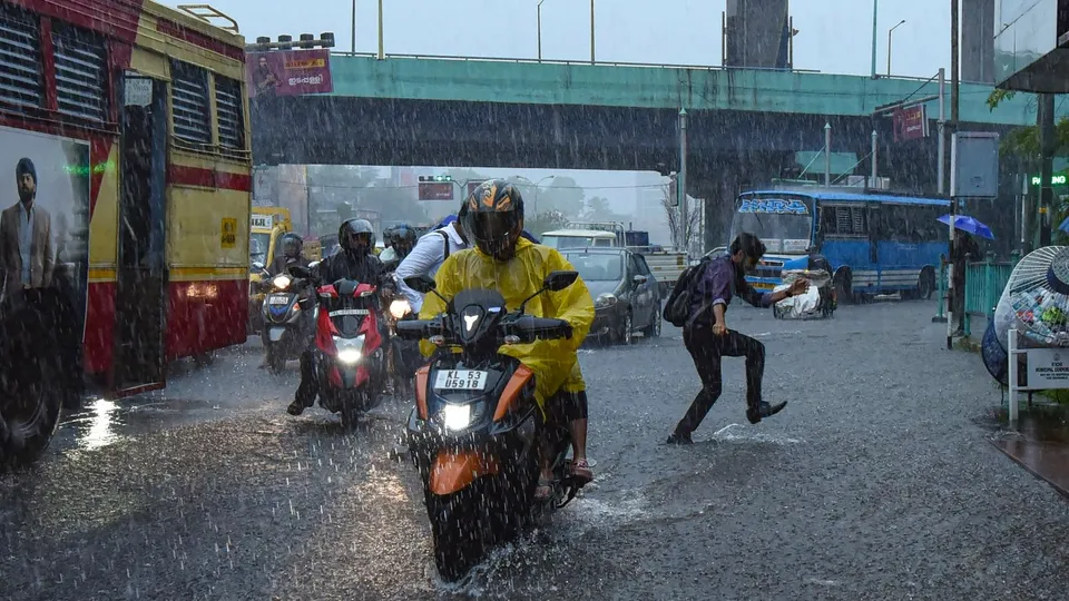 Vehicles move through a flooded street during rain, in Kochi, Tuesday, May 28, 2024