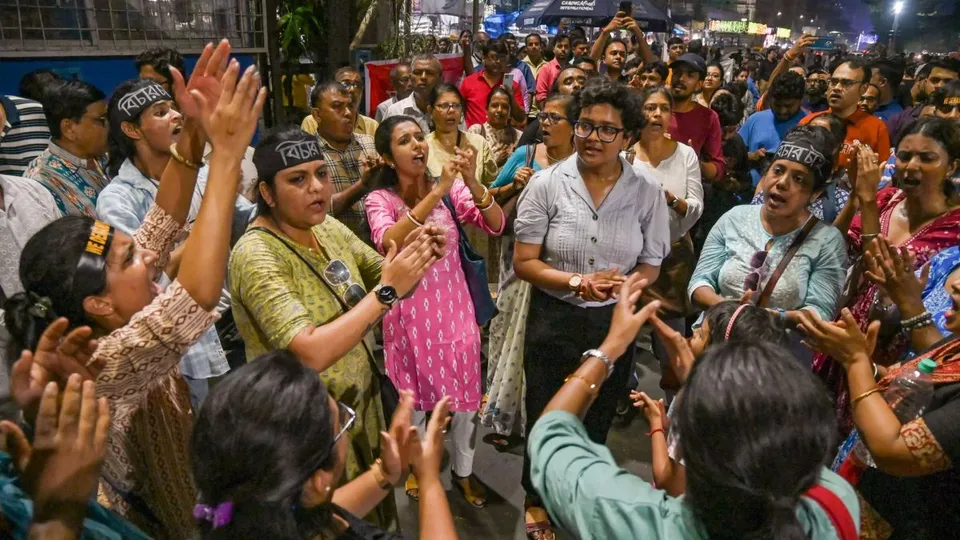 People raise slogans at the protest site where junior doctors are sitting on a hunger strike in hospital