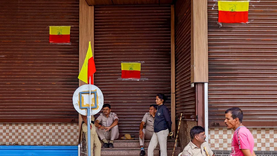 Police personnel outside a closed hotel during a 'bandh' called by farmers and Kannada organisations against the release of Cauvery river water to Tamil Nadu from dams in Karnataka, in Bengaluru