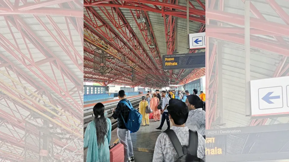 A group of people stands on the platform at the red line metro station, waiting for the arrival of the train.