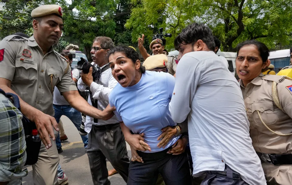 Security personnel detain wrestler Sakshi Malik during wrestlers' protest march towards new Parliament building, in New Delhi