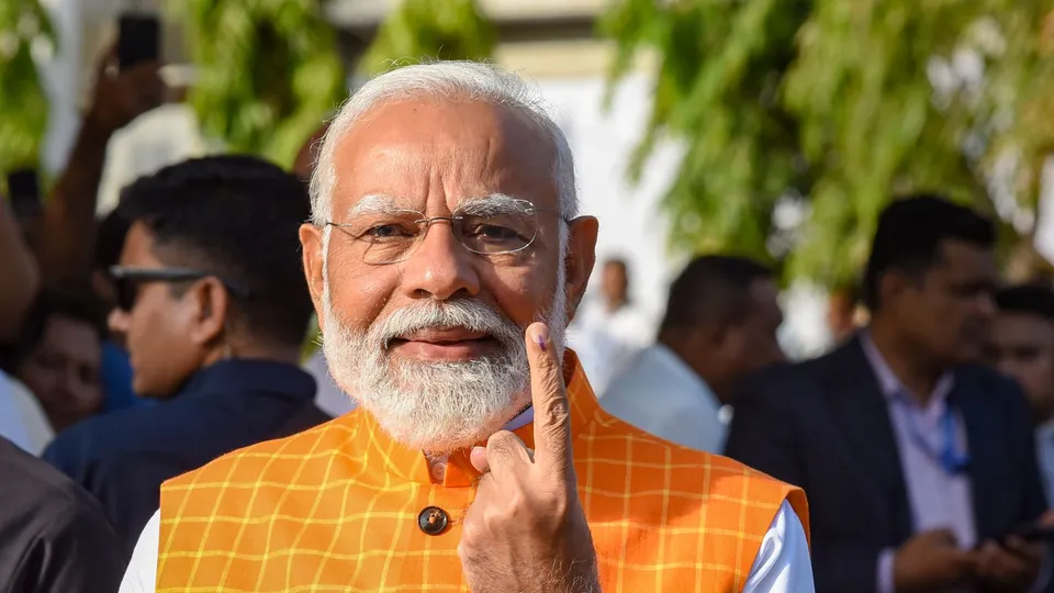 Prime Minister Narendra Modi shows his ink-marked finger after casting his vote at a polling station during the third phase of Lok Sabha elections, in Ahmedabad, Tuesday, May 7, 2024