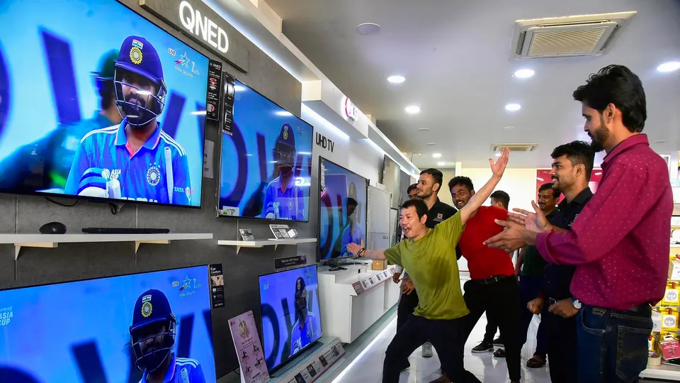 People watch Asia Cup cricket match between India and Pakistan, at a TV showroom, in Bikaner