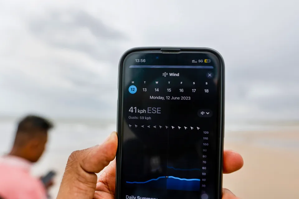 A man checks the wind speed ahead of the landfall of Biparjoy cyclone, in Mandvi of Kutch district
