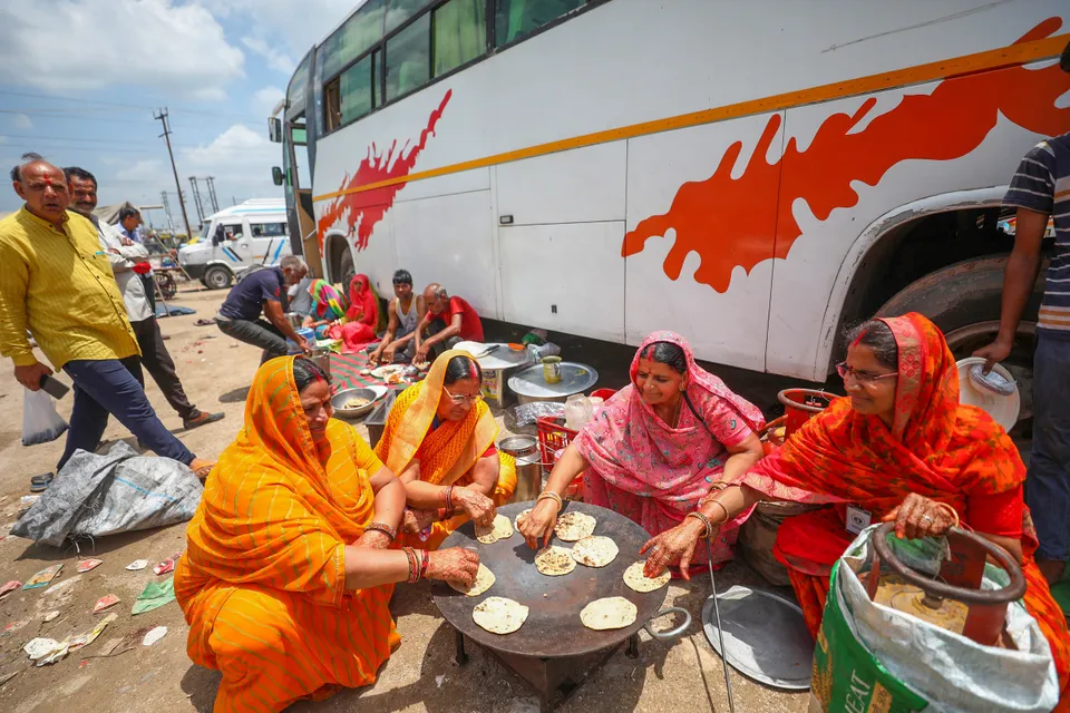 Stranded pilgrims prepare food after the Amarnath Yatra was temporarily suspended due to bad weather, in Jammu, Monday.jpg