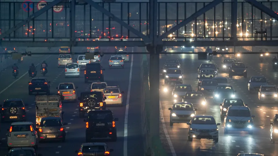 Commuters on a foot overbridge amid smog, in New Delhi
