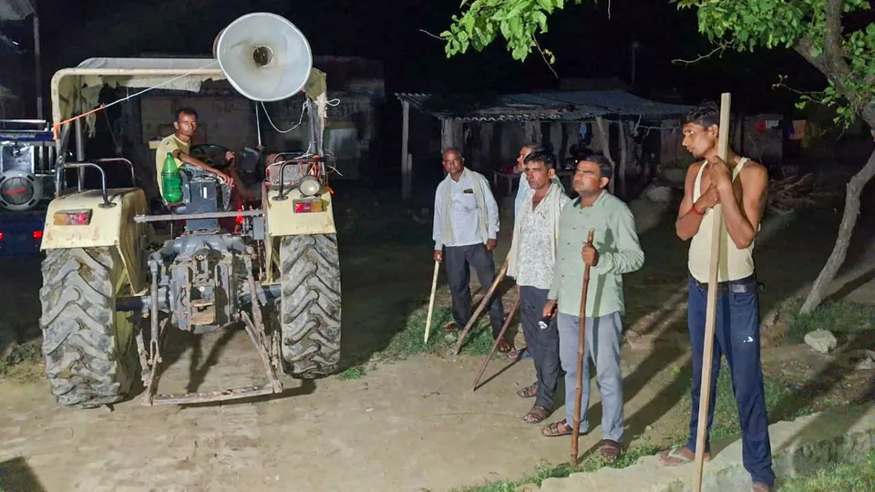 Locals stand guard with sticks and rods to keep a vigil amid wolf attacks, at Orahi village, in Bahraich district, early Wednesday, Sept. 4, 2024.