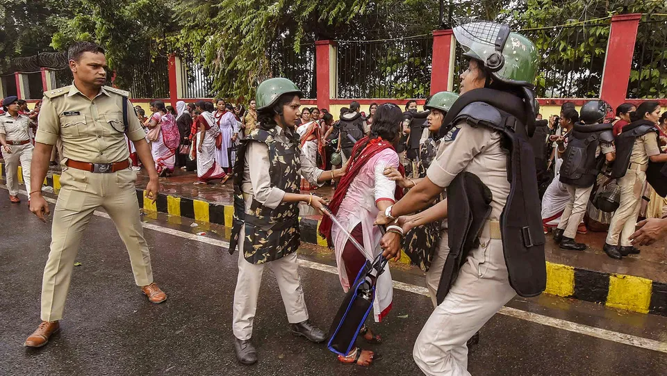 Security personnel detain Anganwadi workers protesting outside the Bihar Legislative Assembly, in Patna