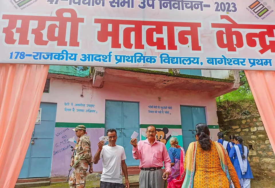 Voters show their identification cards as they arrive to cast their votes during the by-elections to Bageshwar assembly seat, in Uttarakhand's Bageshwar district