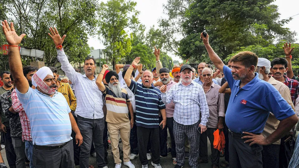 Drivers of the private vehicles shout slogans while protesting outside Jammu Railway Station, in Jammu