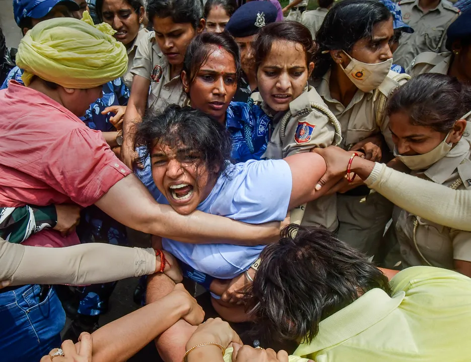 Security personnel detain wrestler Sakshi Malik during wrestlers' protest march towards new Parliament building