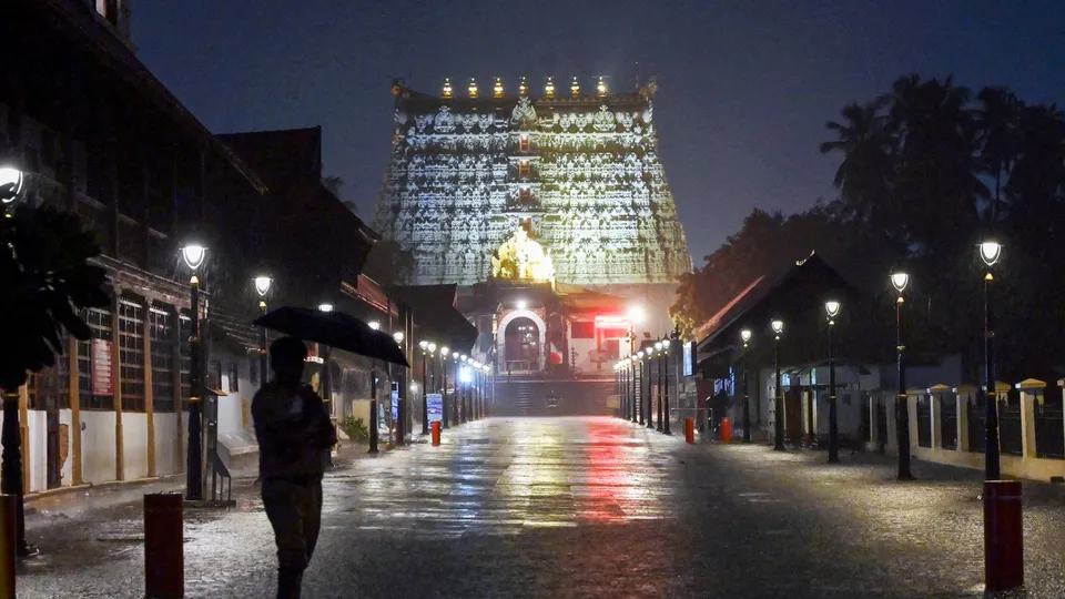 A security personnel stands guard in front of the Sree Padmanabhaswamy temple amid rain, in Thiruvananthapuram, Saturday, May 18, 2024