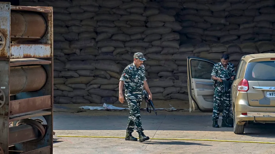 Security personnel stand guard as the Enforcement Directorate (ED) officials conducting raids at the premises of a rice mill in connection with the alleged recruitment scam in the municipalities, in Nadia