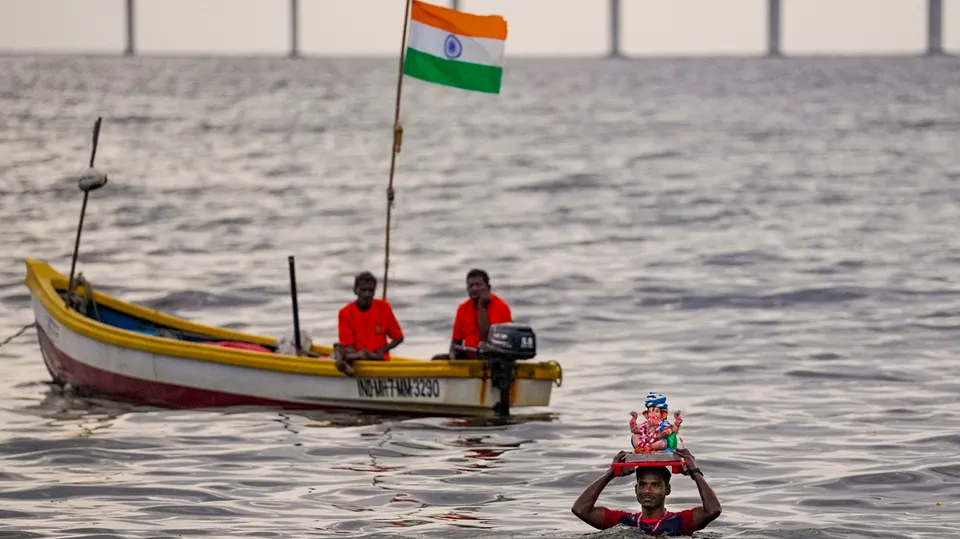 A devotee carries an idol of the Lord Ganesha for immersion in the Arabian Sea amid celebration of the Ganesh Chaturthi festival, in Mumbai