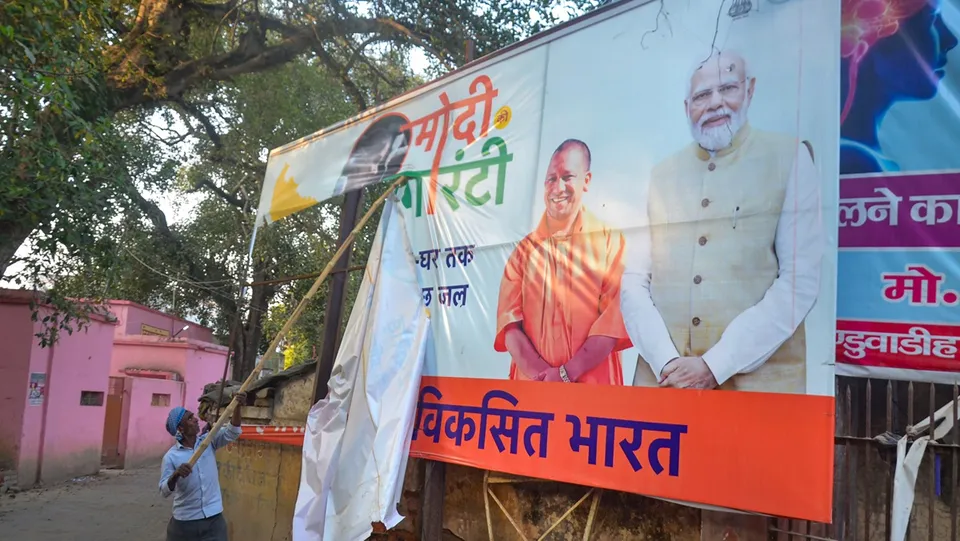 Workers remove political banners after the Model Code of Conduct was enforced following the announcement of the schedule of Lok Sabha elections, in Lucknow, Saturday, March 16, 2024.