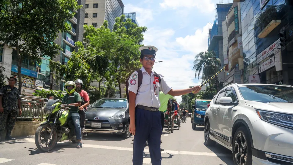 A Bangladeshi student tries to control the traffic as traffic policemen did not turn out on their duty, in Dhaka, Bangladesh, 07 August 2024.