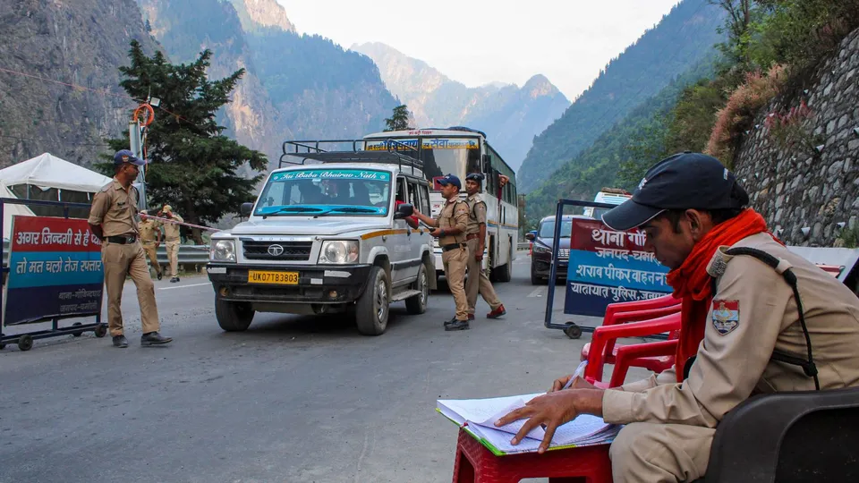 Police personnel check registration of 'Char Dham Yatra' pilgrims on a road leading to Badrinath temple, in Chamoli district, Tuesday, May 23, 2024
