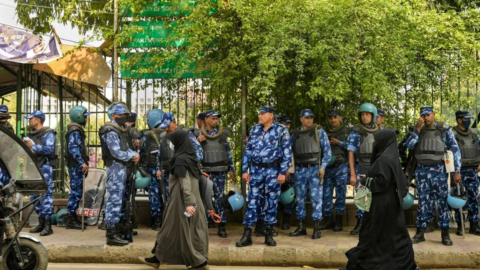 Security personnel stand guard a day after the Ministry of Home Affairs notified the rules for implementation of the Citizenship (Amendment) Act, at Jamia in New Delhi,