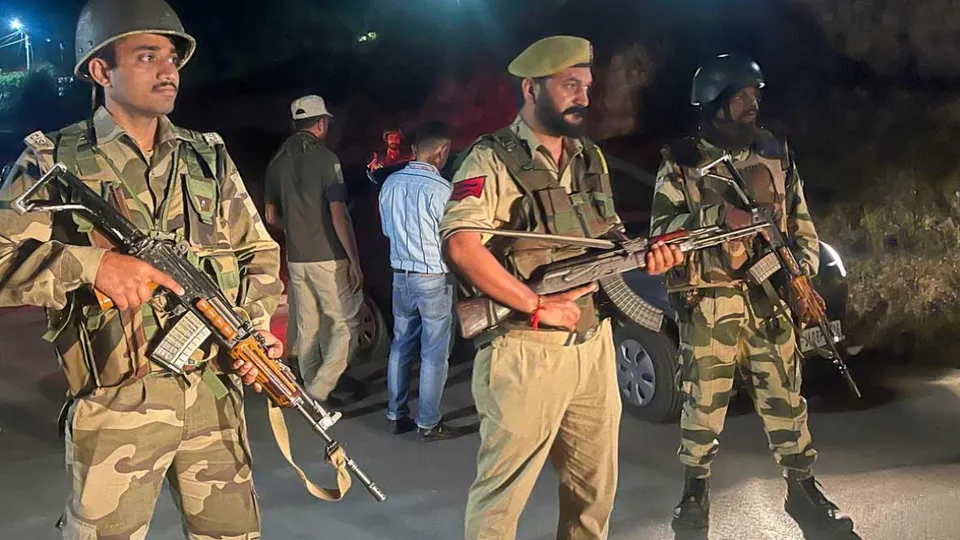 Security personnel stand guard along the Bani-Billawar road after an encounter between security forces and terrorists, in Jammu and Kashmir's Kathua