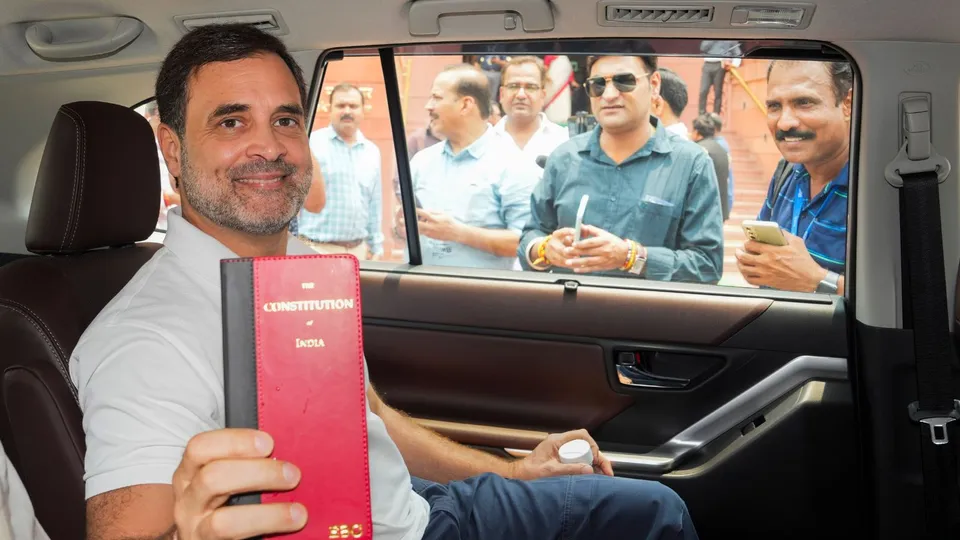 Congress member Rahul Gandhi shows a book of Constitution of India at the Parliament House complex on the first day of the first session of the 18th Lok Sabha, in New Delhi, Monday, June 24, 2024.