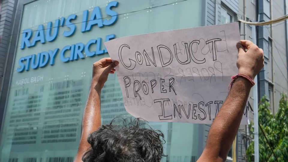 A student raises a placard during a protest outside Rau's IAS Study Circle at Old Rajinder Nagar, in New Delhi, Sunday, July 28, 2024.