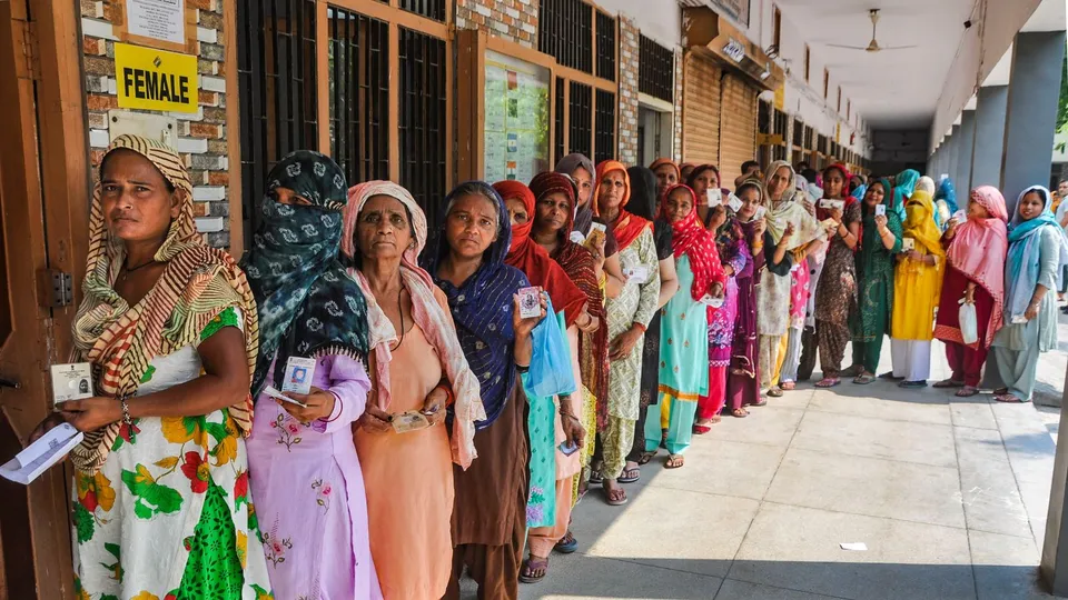 People wait in a queue to cast their votes at a polling booth during the sixth phase of Lok Sabha elections, in Sonipat, Saturday, May 25, 2024