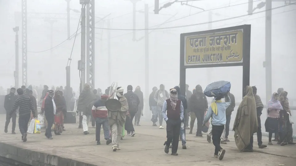 Commuters at the Patna Junction railway station during fog on a cold winter morning, in Patna