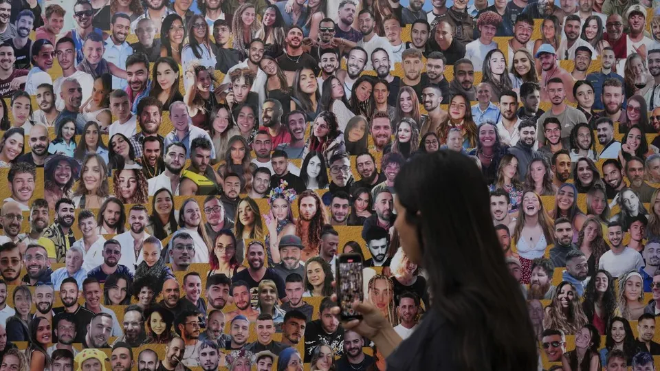 An attendant walks through a mural of victims at the Nova music festival site near Kibbutz Reim, Israel, on the one-year anniversary of the Hamas attack, October 7, 2024