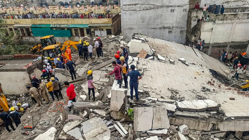 Officials and others during a rescue operation after a building collapse, in Surat district, Saturday, July 6, 2024.