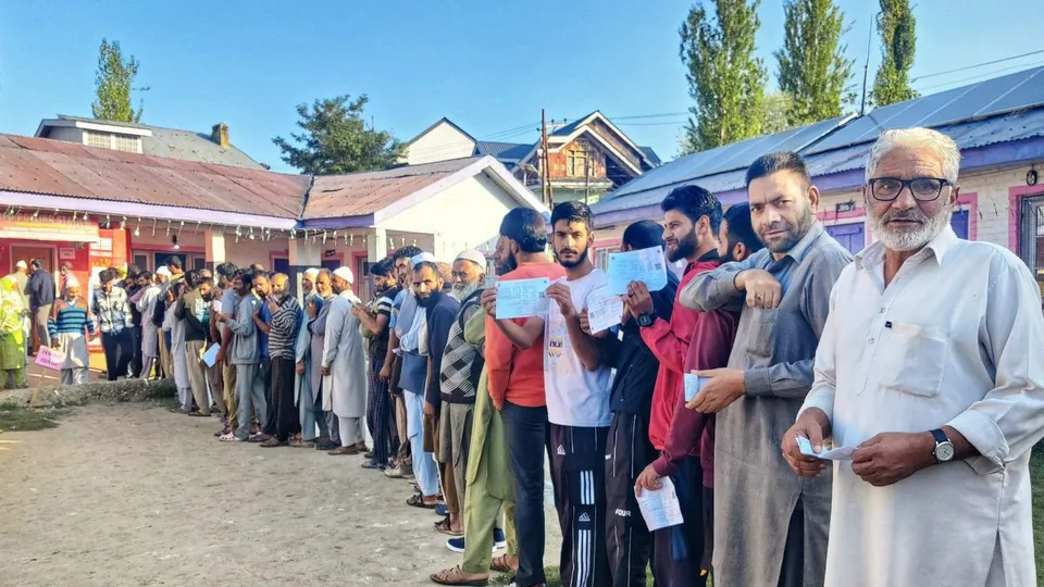 Voters stand in a queue to cast their votes during the first phase of Jammu and Kashmir Assembly elections, in Pulwama district. 