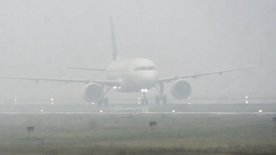 An aeroplane lands at Jai Prakash Narayan airport amid dense fog, in Patna