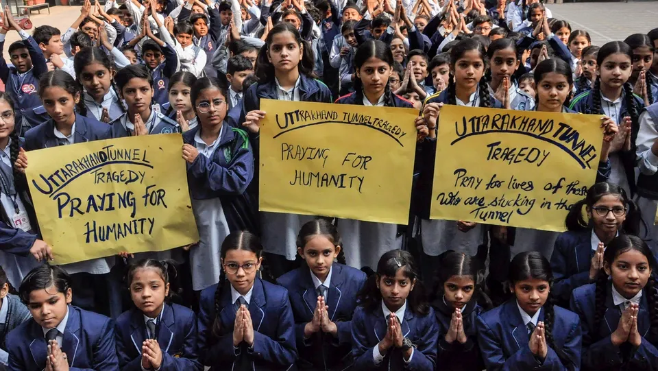 School students pray for the workers trapped inside an under-construction tunnel in Uttarakhand, in Moradabad