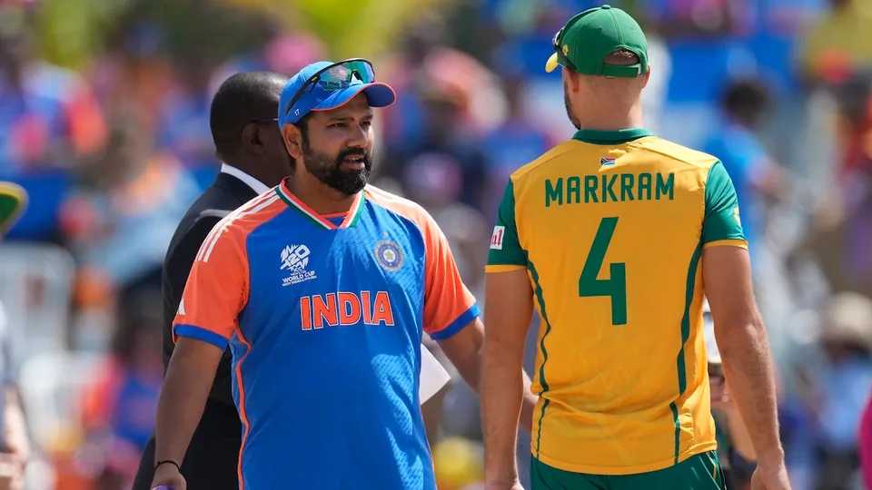 Rohit Sharma, left, speaks to South Africa's captain Aiden Markram at the toss before the start of the ICC Men's T20 World Cup final cricket match between India and South Africa at Kensington Oval in Bridgetown, Barbados, Saturday, June 29, 2024.