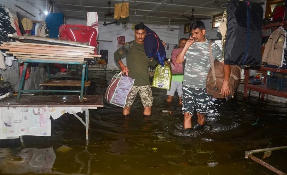 CRPFs 171 battalion jawans shift with their belongings from a flooded area, in Dibrugarh