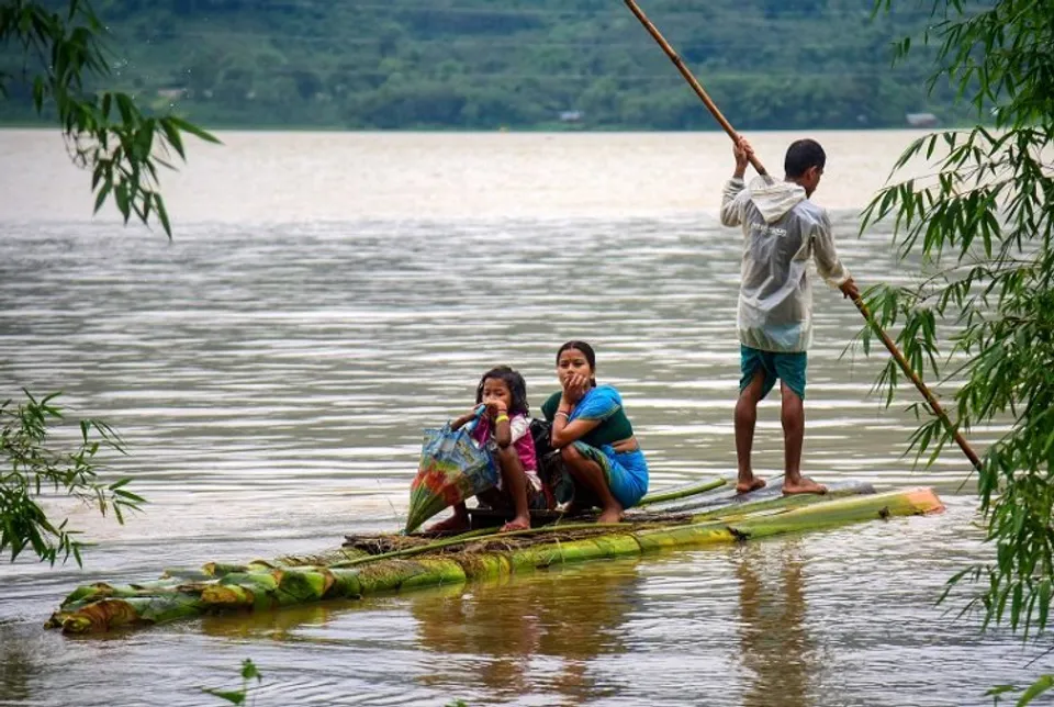 Villagers use a makeshift boat to move to a safer place from a flood-affected area following heavy rainfall 
