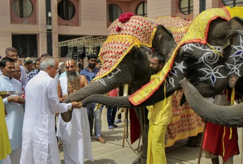 Lord Jagannath Temples head priest Mahant Dilipdas Maharaj pets elephants while offering prayers to them a day before the annual Rath Yatra of Lord Jagannath, in Ahmedabad, Thursday