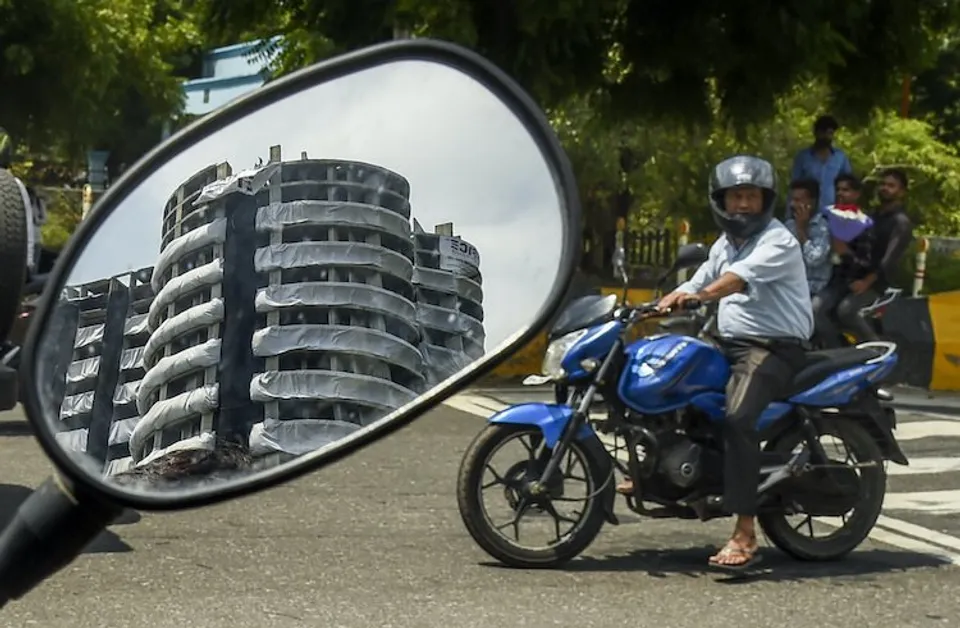 Reflection of Supertech twin tower on a mirror of a bike, ahead of their demolition with explosives in compliance with a Supreme Court order, in Noida, Saturday