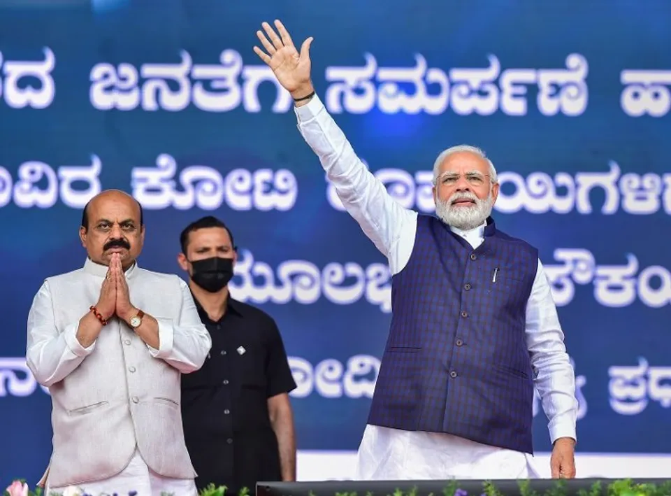 Prime Minister Narendra Modi waves towards supporters during the launch of railway and road projects, in Bengaluru