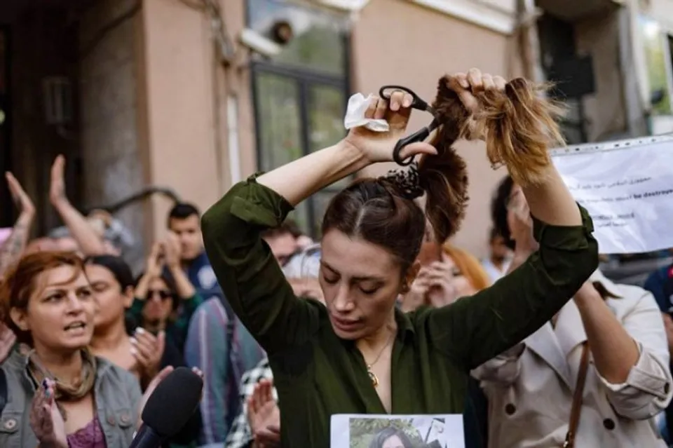 Iranian woman cutting her hair in protest