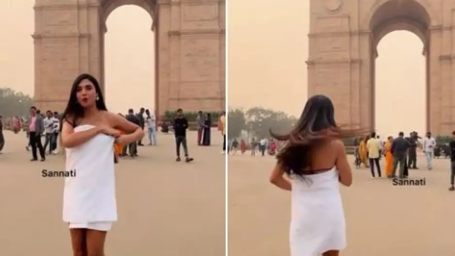 Girl in towel dances in front of India Gate